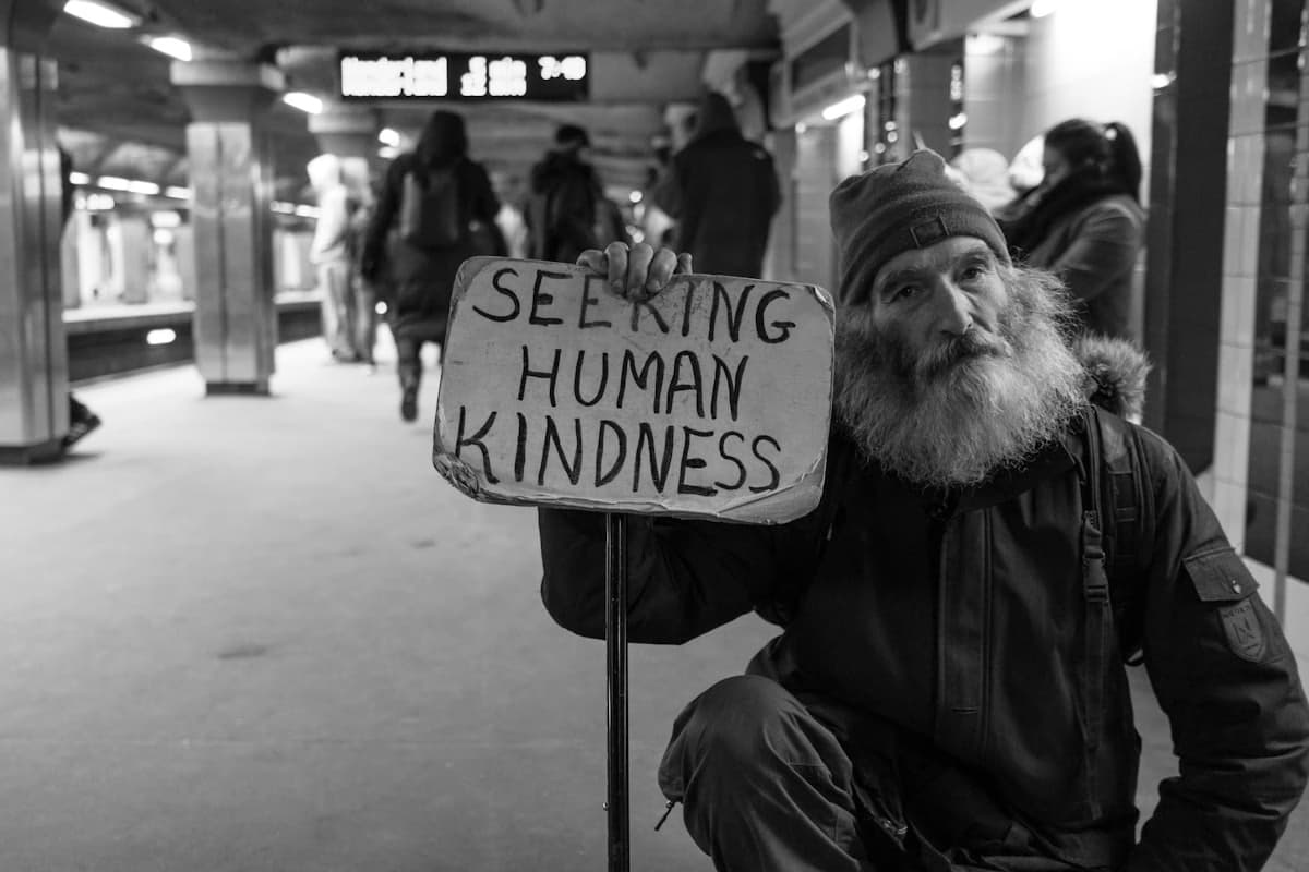 Person holding a sign seeking kindness